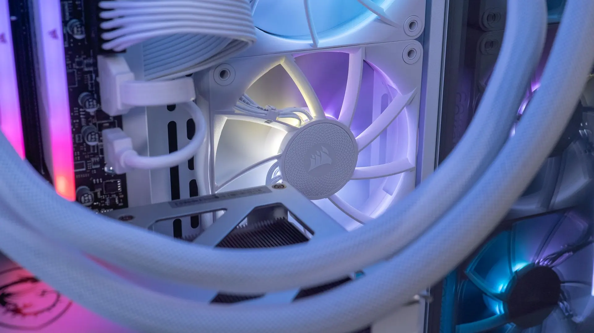 Détail ventilateur blanc Corsair iCUE Link avec tubes de watercooling tressés dans un PC FlowUP