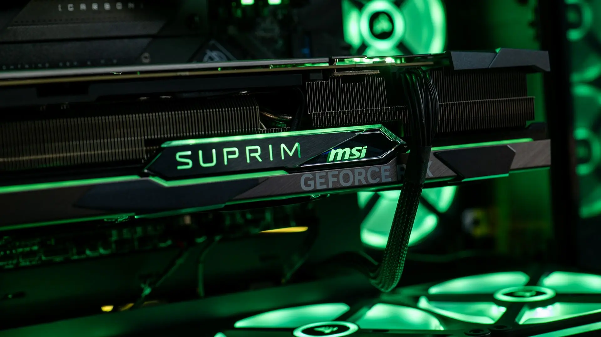 Tranche éclairée de la MSI RTX 4080 Suprim X avec logo RGB vert dans une configuration PC FlowUP