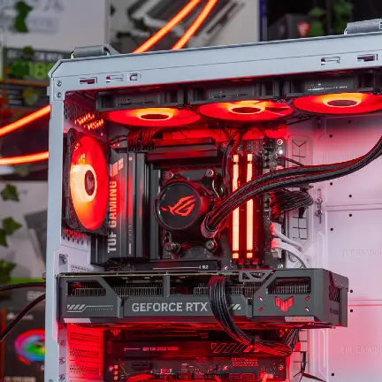 Intérieur d’un PC gamer TUF Gaming avec carte graphique RTX, refroidissement liquide et câbles d’alimentation visibles Cette image montre l’intérieur bien organisé d’un PC gaming haut de gamme, équipé d’un système de refroidissement liquide ROG, de barrettes RAM RGB, d’une carte graphique GeForce RTX, et de plusieurs câbles d’alimentation internes visibles. Elle illustre l’étape cruciale de vérification des branchements internes pour résoudre un problème de démarrage PC. Les câbles CPU (EPS 8 pins) et PCIe GPU doivent être fermement insérés, car un déplacement ou une mauvaise manipulation peut entraîner une déconnexion partielle. L’utilisation d’une lampe de smartphone est recommandée pour suivre les câbles depuis l’alimentation jusqu’aux composants clés, assurant ainsi une alimentation stable et continue.