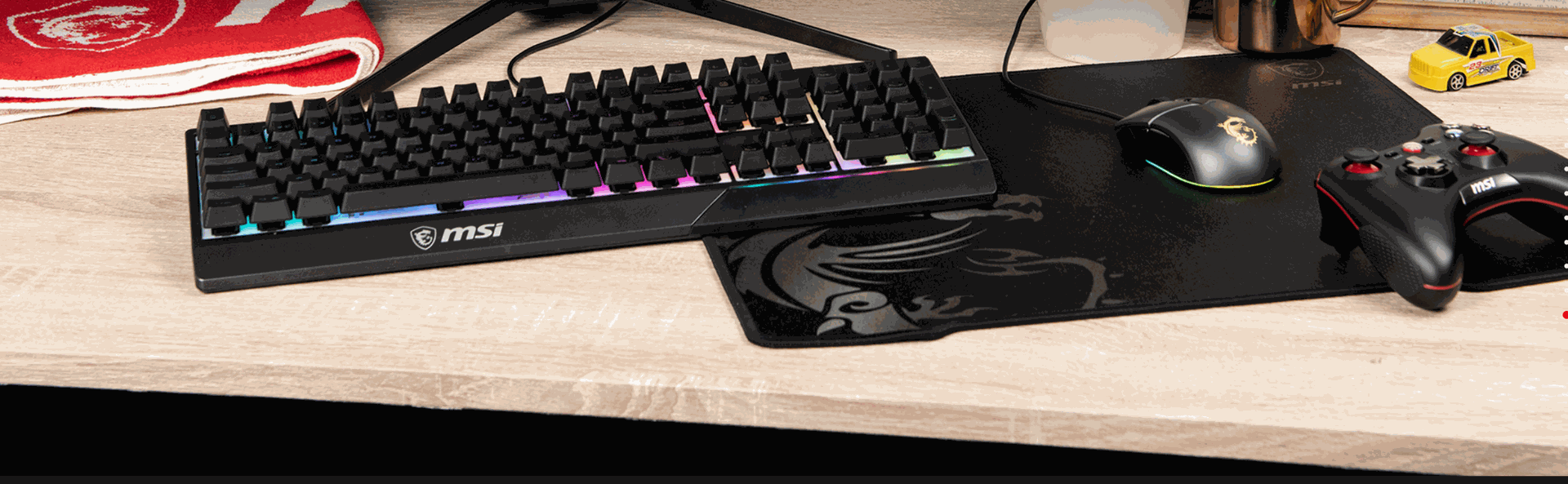 Mise en situation du pack MSI Vigor GK30 Combo sur un bureau gamer avec tapis de souris et manette MSI chez FlowUP