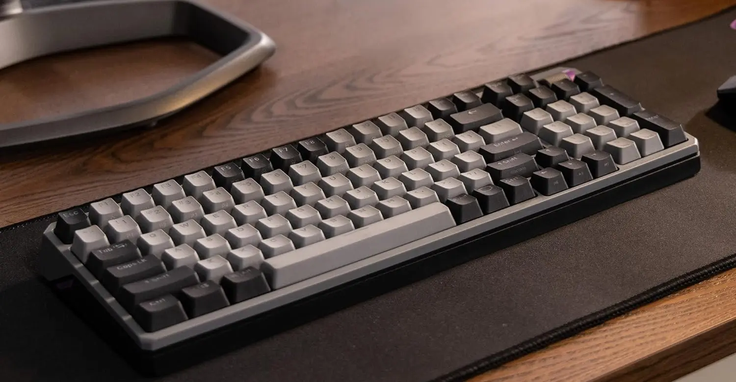 Vue d'angle du clavier Cooler Master MK770 Gris Spatial montrant ses touches bicolores et sa structure compacte sur un tapis de souris chez FlowUP